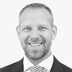 [Translate to Deutsch:] Portraitbild des Referenten in schwarz-weiß, Lars Trapper