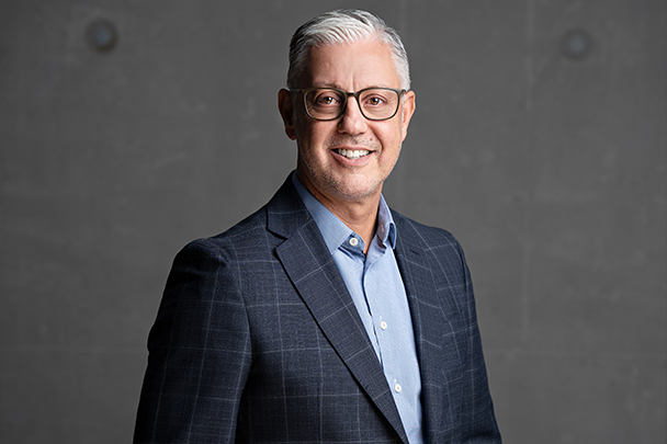 Portraitbild von Martin Lugert Geschäftsführer | Camlog Close-up von Martin Lugertvor einer dunkel grauen Betonwand